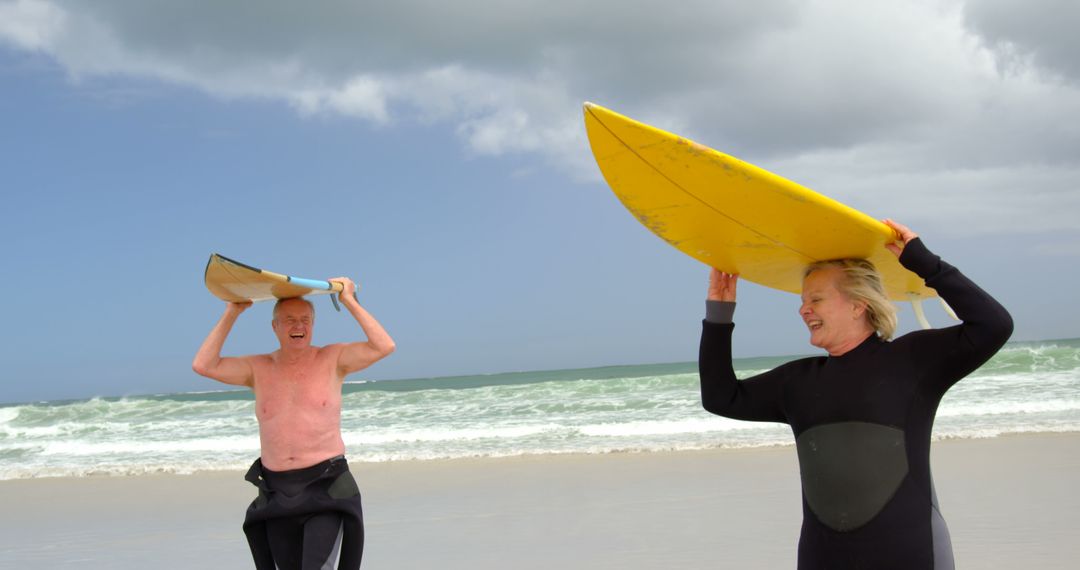 Senior Couple Holding Surfboards on Beach Laughing - Free Images, Stock Photos and Pictures on Pikwizard.com