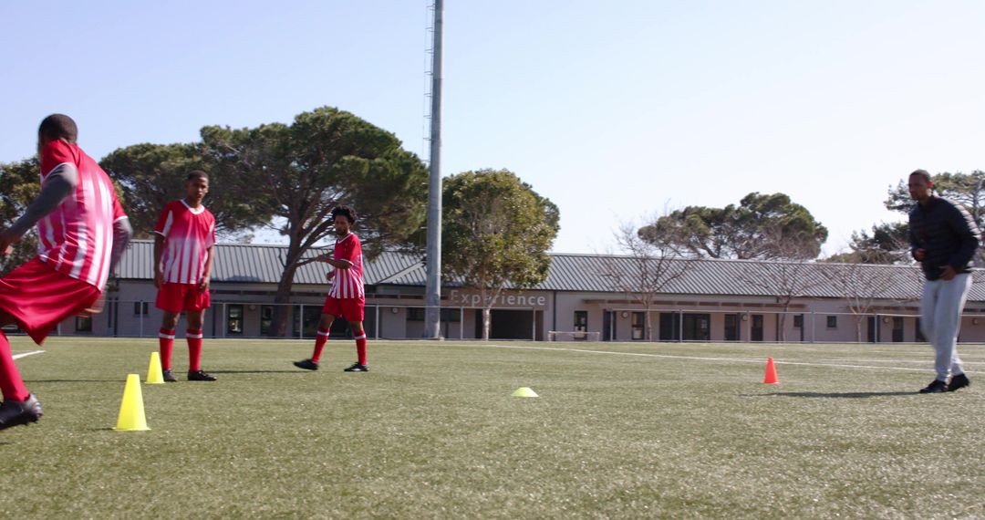 Boys in Red Soccer Uniforms Practicing Agility on School Field