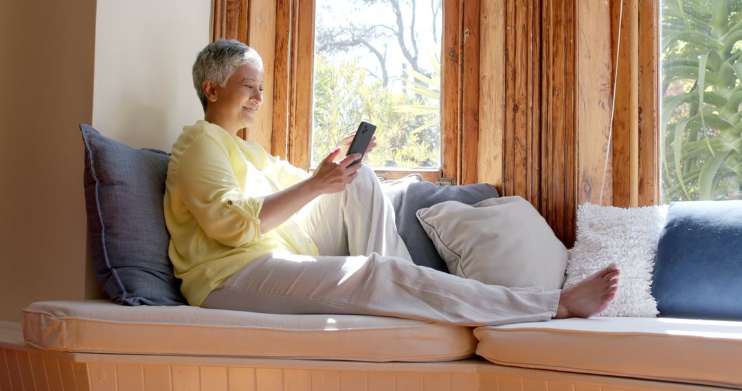 Senior Woman Relaxing on Couch Using Smartphone at Home