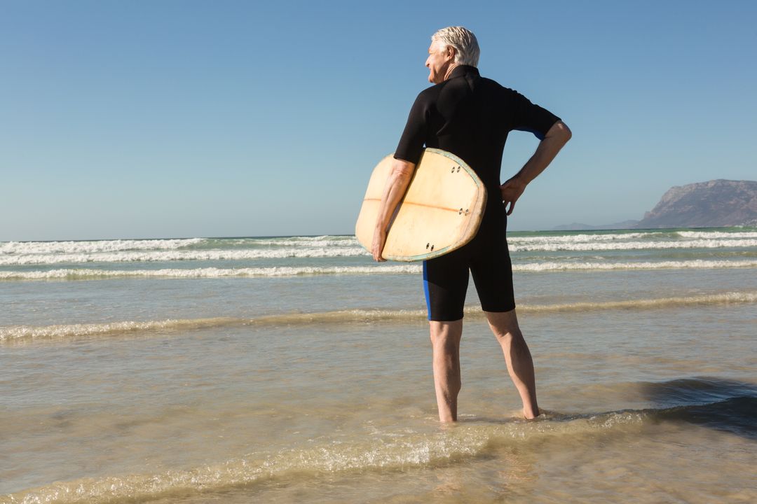 Senior Man Holding Surfboard at Beach - Free Images, Stock Photos and Pictures on Pikwizard.com