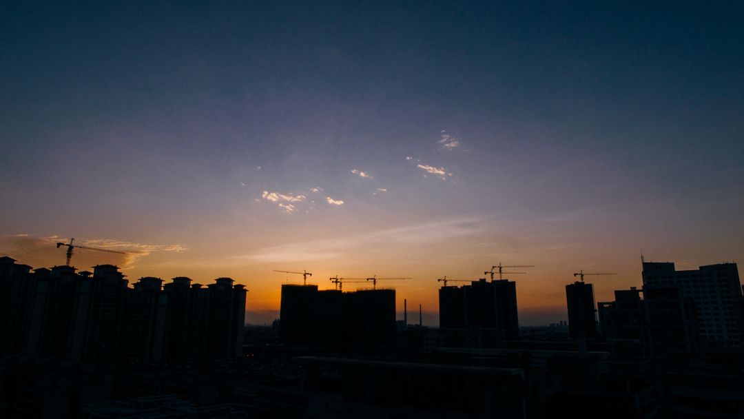 Urban skyline during sunset with construction cranes - Free Images, Stock Photos and Pictures on Pikwizard.com