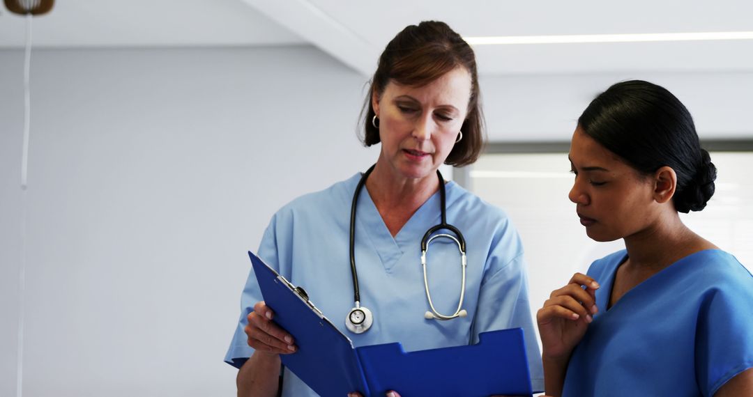 Medical Team Discussing Patient Notes in Hospital Room - Free Images, Stock Photos and Pictures on Pikwizard.com