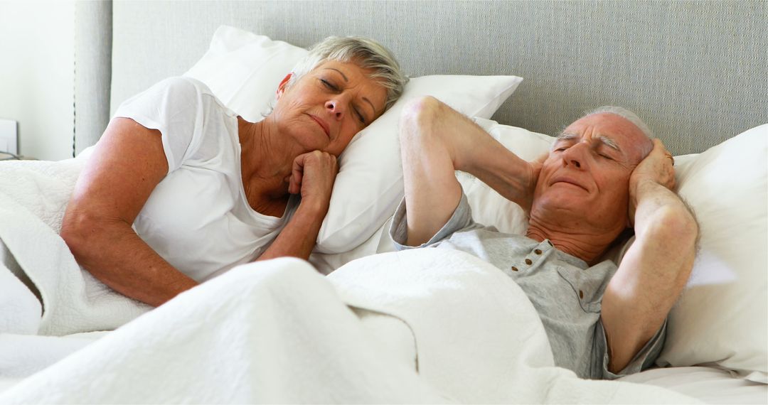 Senior Couple Sleeping Comfortably in Bedroom Bed - Free Images, Stock Photos and Pictures on Pikwizard.com