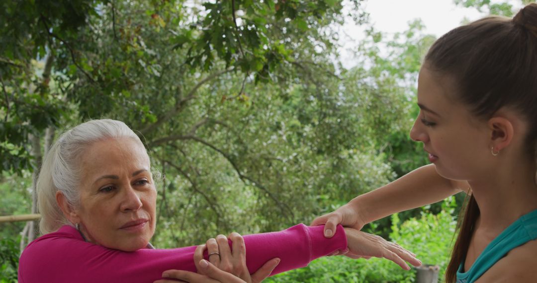 Elderly Woman Receiving Shoulder Stretching Assistance Outdoors - Free Images, Stock Photos and Pictures on Pikwizard.com