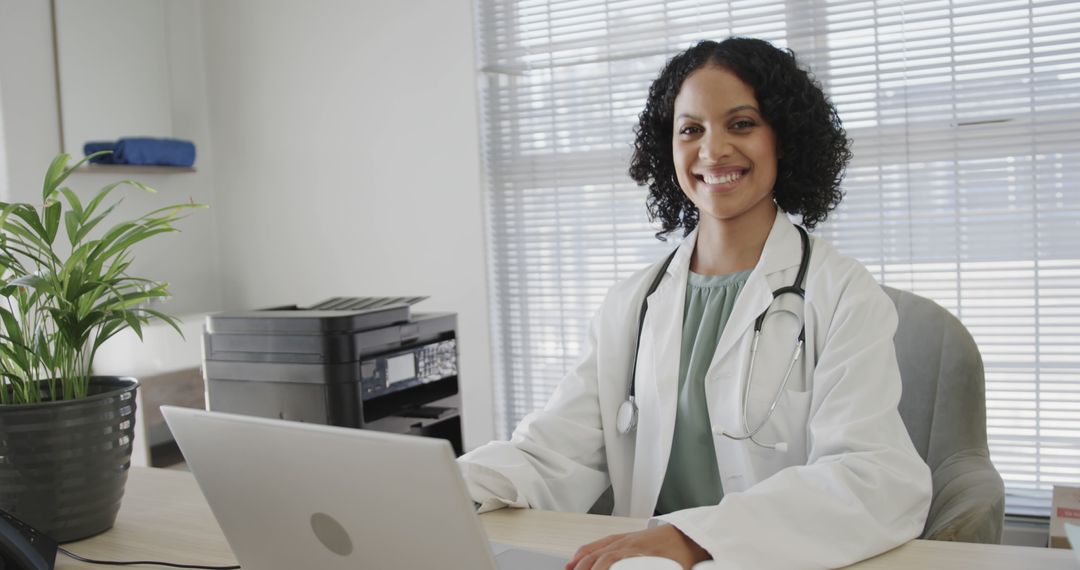 Smiling Female Doctor Using Laptop in Modern Office - Free Images, Stock Photos and Pictures on Pikwizard.com