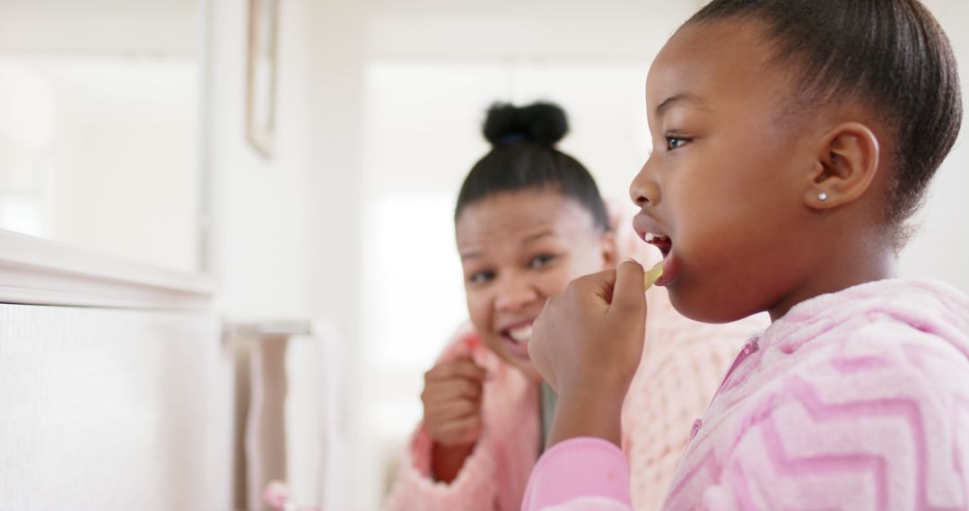 Mother Encouraging Daughter while Brushing Teeth - Free Images, Stock Photos and Pictures on Pikwizard.com