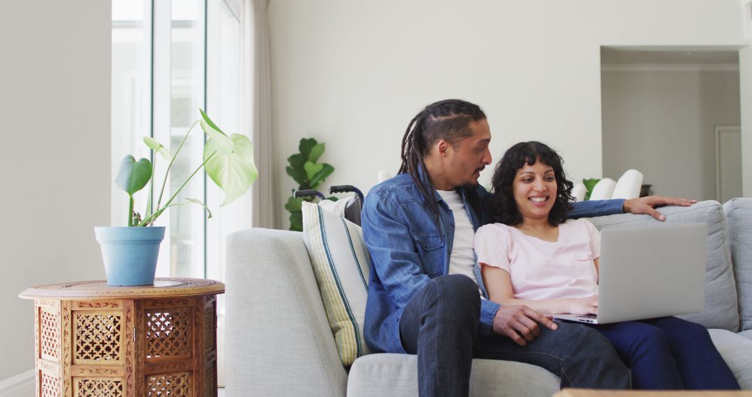 Happy Couple Using Laptop on Couch at Home