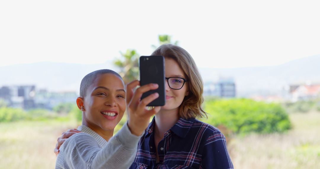 Two Friends Taking Selfie Outdoors with Greenery Background - Free Images, Stock Photos and Pictures on Pikwizard.com