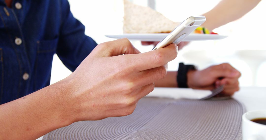 Person Using Smartphone While Dining in Casual Restaurant - Free Images, Stock Photos and Pictures on Pikwizard.com