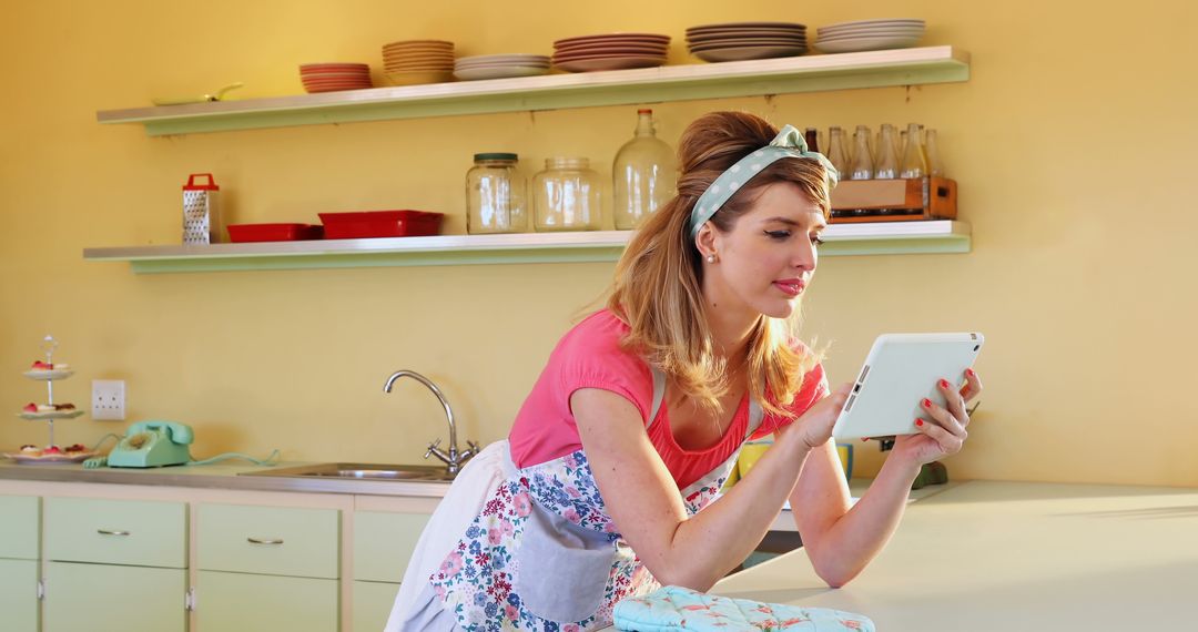 Woman in Retro Kitchen Using Tablet and Leaning on Counter - Free Images, Stock Photos and Pictures on Pikwizard.com