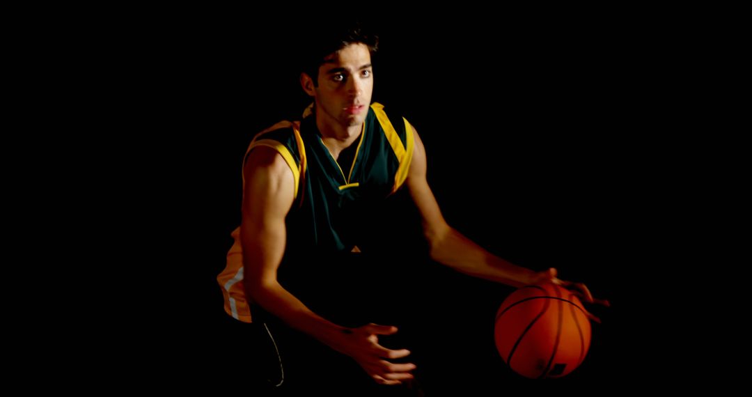 Focused Basketball Player in Dim Lighting Displaying Skill