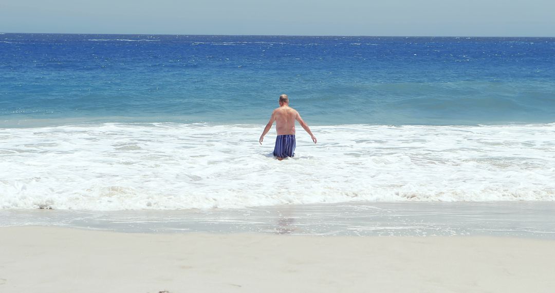 Man Enjoying Tranquil Ocean Waves on Sandy Beach - Free Images, Stock Photos and Pictures on Pikwizard.com