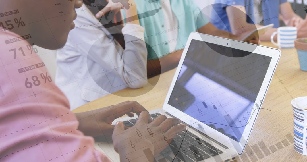 Diverse Team Analyzing Financial Graphs on Laptop in Modern Office
