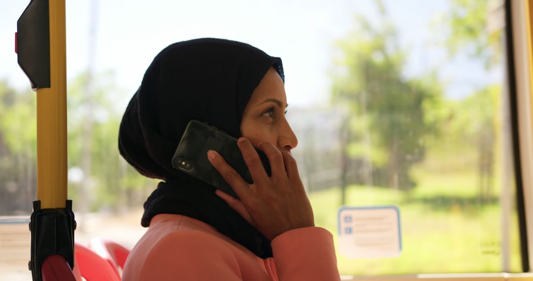 Woman in Hijab Talking on Smartphone on Public Transportation - Free Images, Stock Photos and Pictures on Pikwizard.com