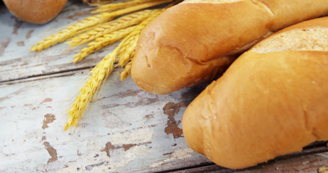 Freshly Baked Baguettes on Rustic Wooden Table with Wheat Ears - Free Images, Stock Photos and Pictures on Pikwizard.com