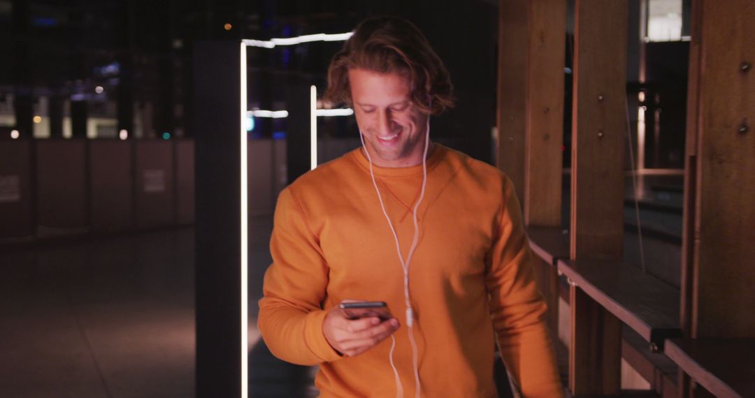 Man Enjoying Music on Smartphone During Night Walk - Free Images, Stock Photos and Pictures on Pikwizard.com