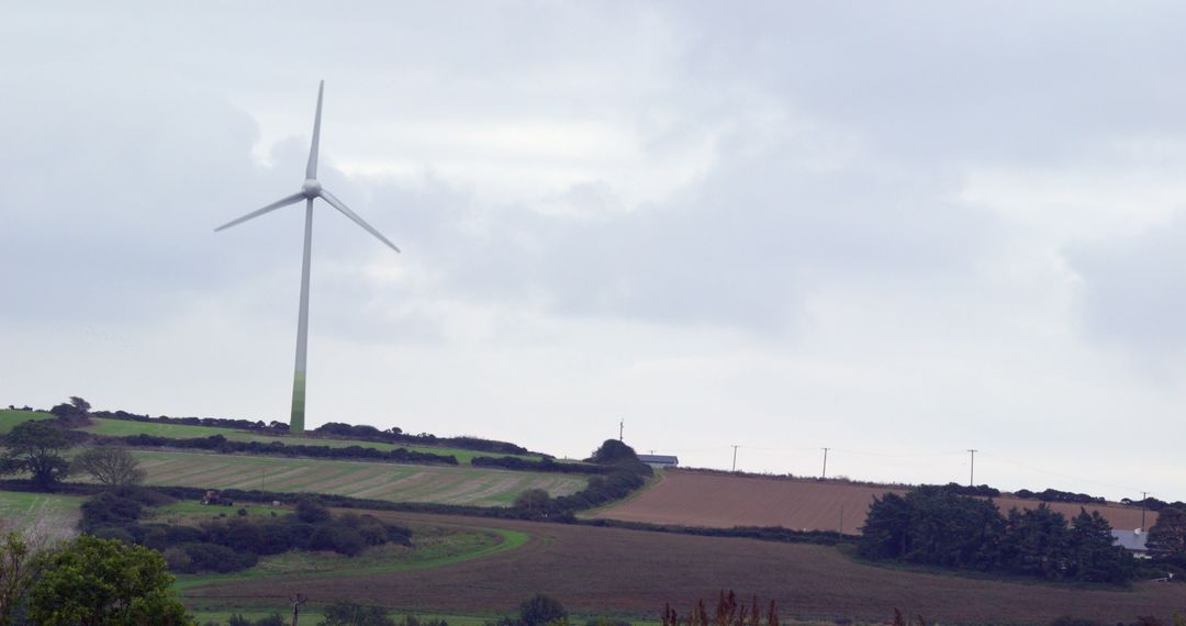 Wind Turbine in Rural Landscape Under Overcast Sky - Free Images, Stock Photos and Pictures on Pikwizard.com