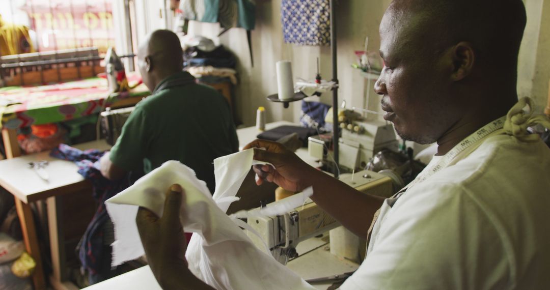 Tailors Working in Sewing Shop with Measuring Tape and Fabrics - Free Images, Stock Photos and Pictures on Pikwizard.com