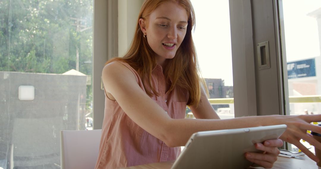 Young Woman Using a Tablet in Modern Cafe - Free Images, Stock Photos and Pictures on Pikwizard.com