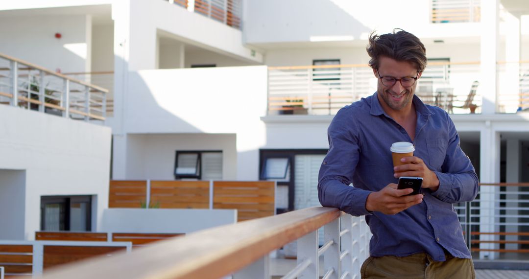 Smiling Man Holding Coffee Cup and Using Smartphone Outdoors - Free Images, Stock Photos and Pictures on Pikwizard.com