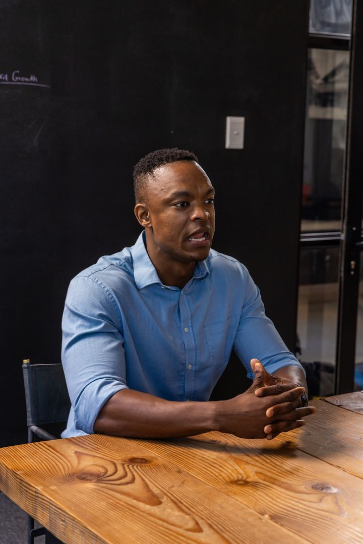 Professional Man Engaging in Meeting Discussion in Modern Workspace