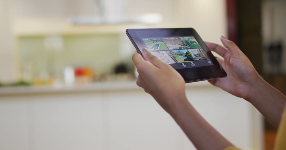 Woman Controlling Home Security System with Tablet in Kitchen - Free Images, Stock Photos and Pictures on Pikwizard.com