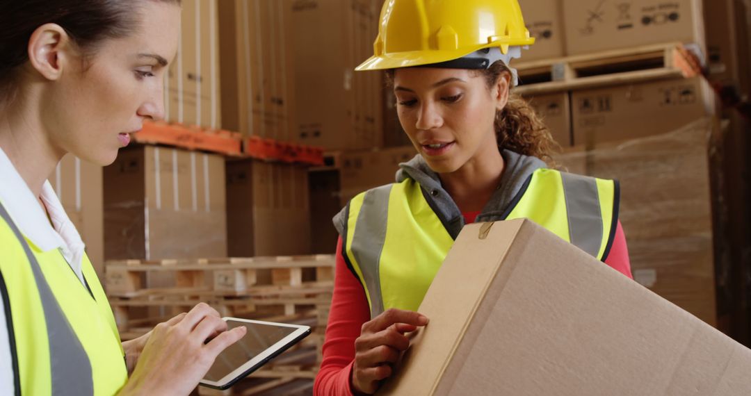 Female Workers Collaborating In Warehouse, Using Tablet And Handling Packages - Free Images, Stock Photos and Pictures on Pikwizard.com