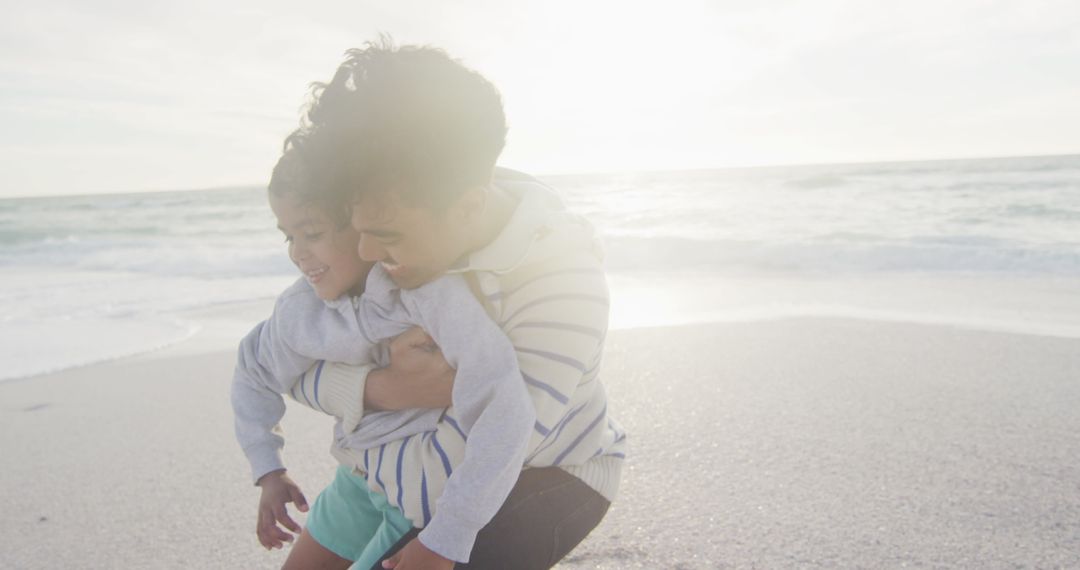 Father Embracing Daughter on Sunny Beach