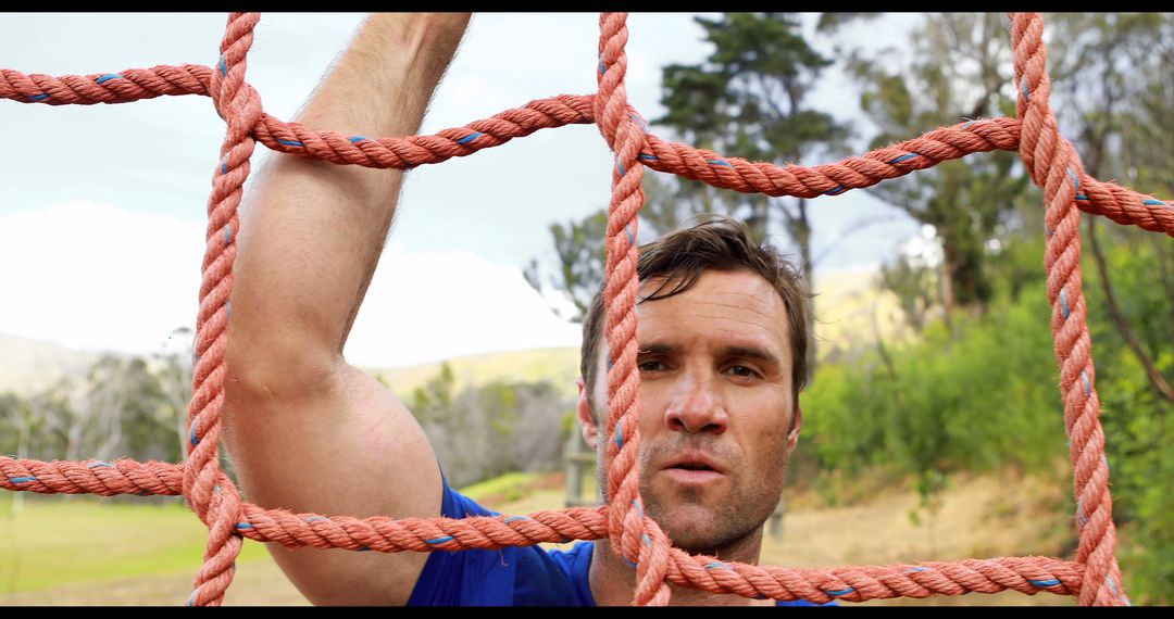 Middle-aged Man Climbing Outdoor Rope Net with Determined Expression - Free Images, Stock Photos and Pictures on Pikwizard.com