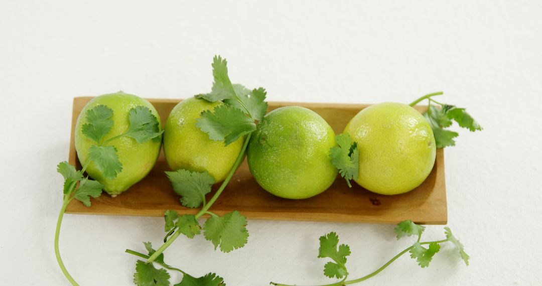 Fresh Limes with Cilantro on Wooden Tray - Free Images, Stock Photos and Pictures on Pikwizard.com