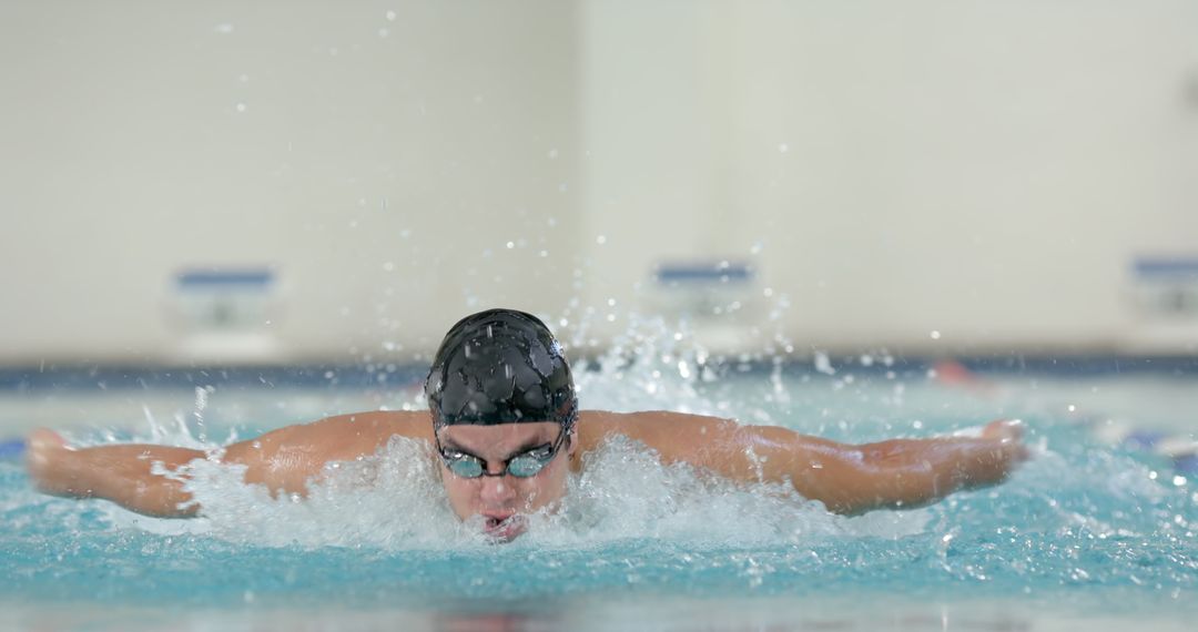 Professional Swimmer Performing Butterfly Stroke in Pool