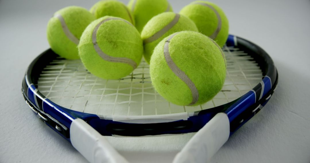 Close-Up of Tennis Balls on Racket with Focus on Equipment