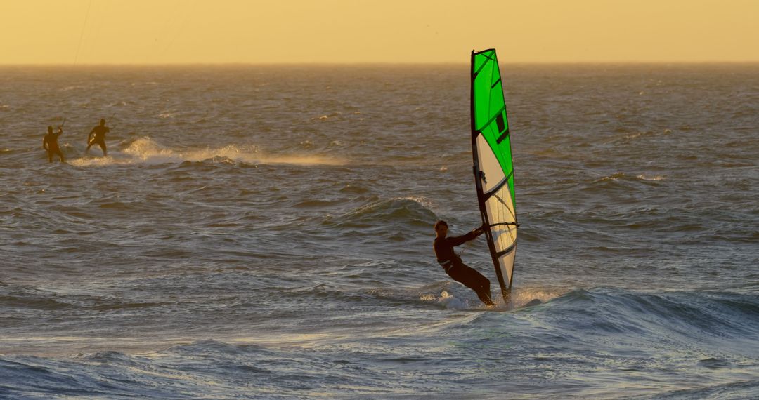 Windsurfer Enjoying Ocean Waves During Sunset - Free Images, Stock Photos and Pictures on Pikwizard.com