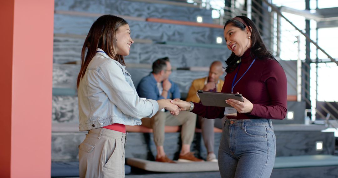 Multicultural professionals greeting and networking in modern atrium workspace during conference