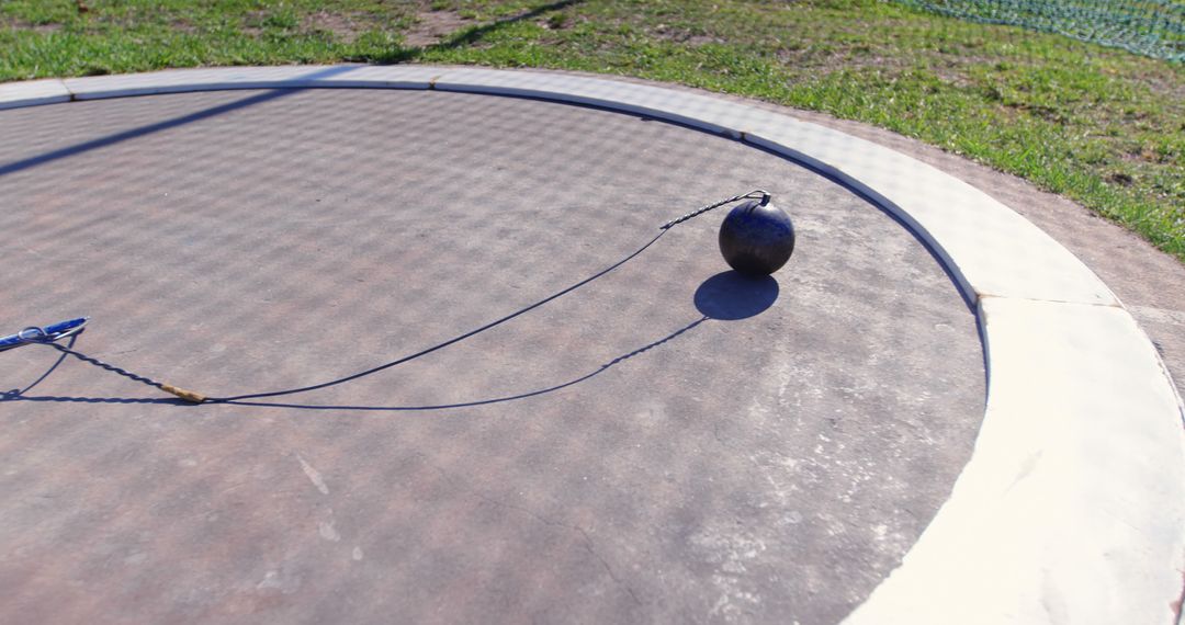 Hammer Throw Equipment on Athletic Field on Sunny Day