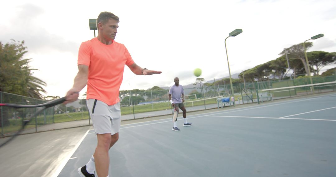 Men Practicing Tennis on Outdoor Court in Casual Sportswear - Free Images, Stock Photos and Pictures on Pikwizard.com