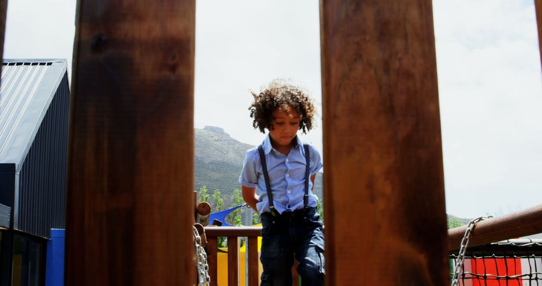 Biracial Boy with Curly Hair Playing on Playground