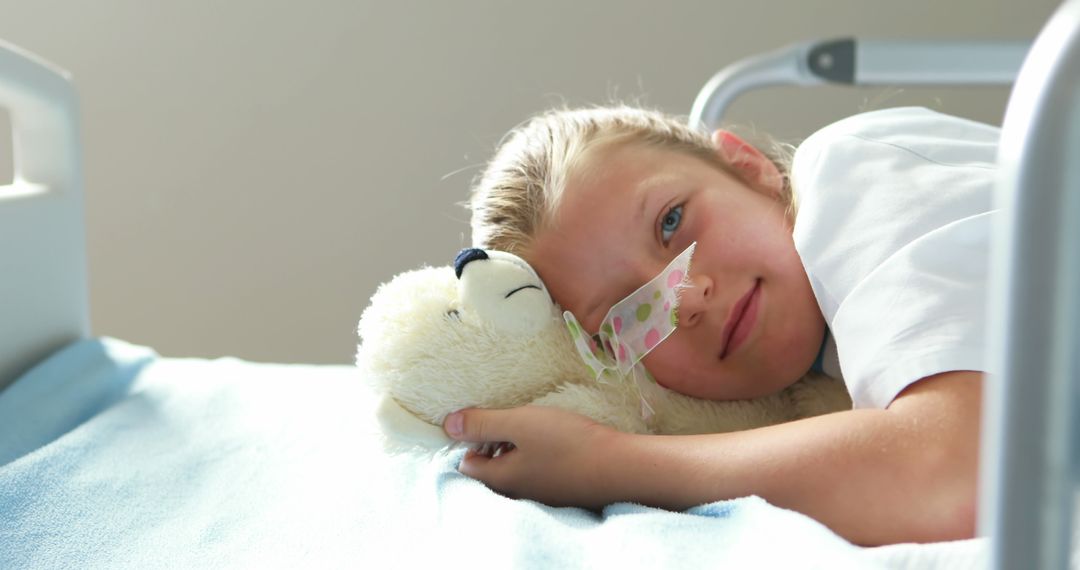 Girl in Hospital Bed Hugging Teddy Bear Smiling Gently - Free Images, Stock Photos and Pictures on Pikwizard.com