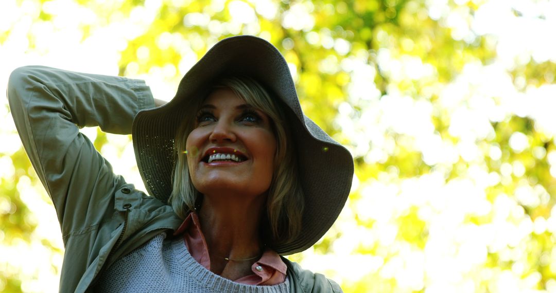 Joyful Middle-Aged Woman Enjoying Nature in Wide-Brimmed Hat - Free Images, Stock Photos and Pictures on Pikwizard.com