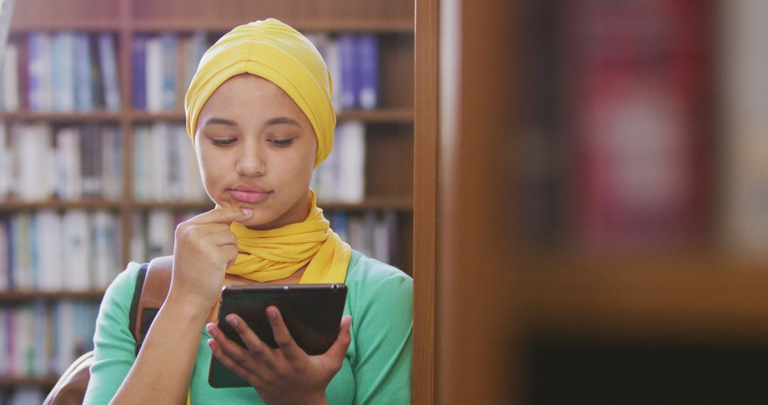 Young Muslim Woman Studying on Digital Tablet in Library - Free Images, Stock Photos and Pictures on Pikwizard.com