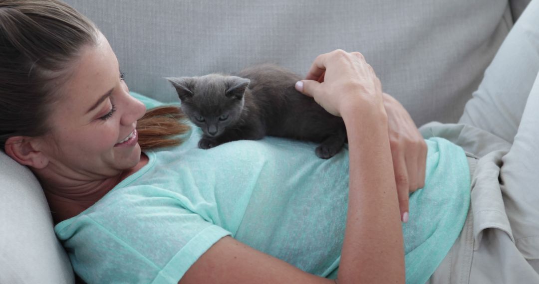 Woman Relaxing at Home with Playful Kitten on Couch