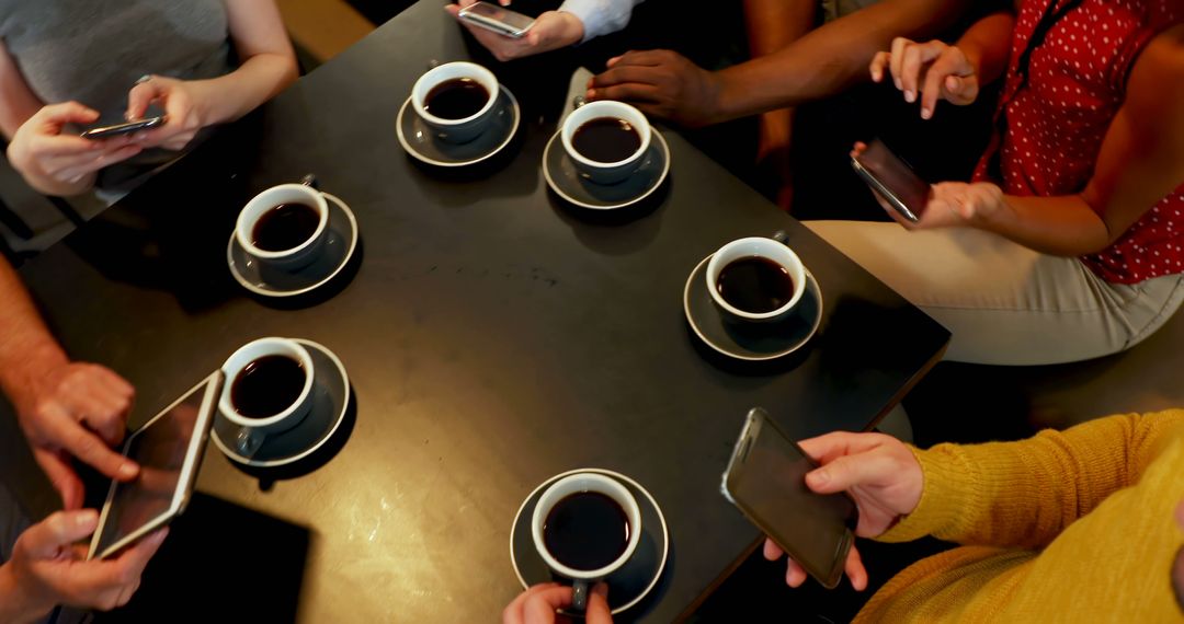 Group of friends using smartphones and drinking coffee at café - Free Images, Stock Photos and Pictures on Pikwizard.com