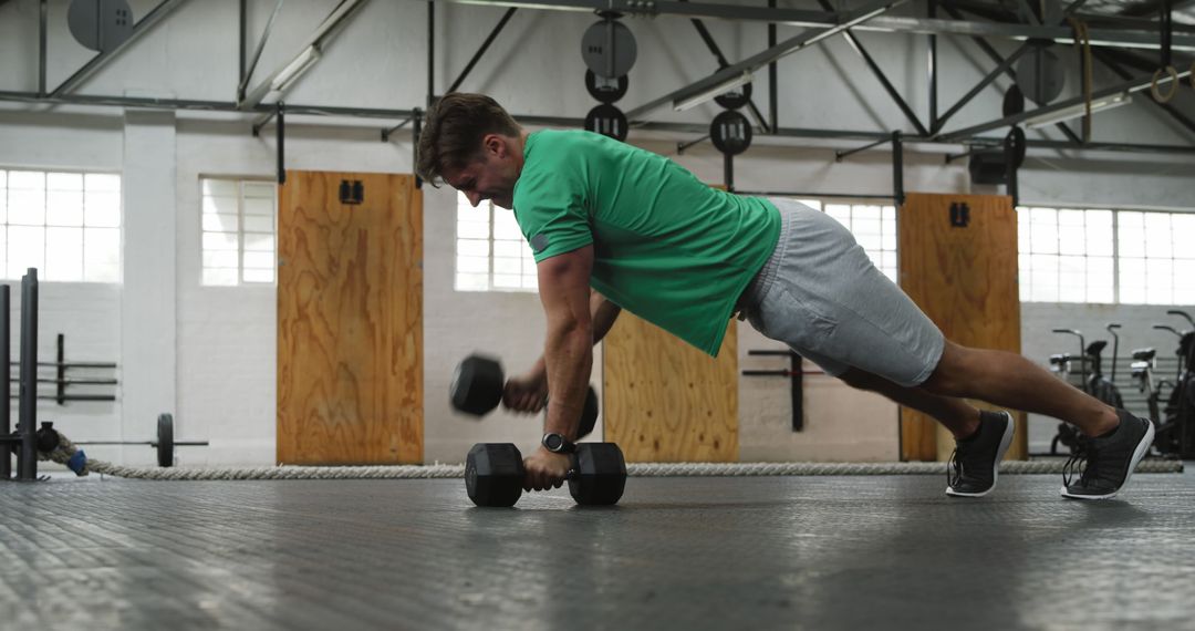 Man Performing Renegade Rows with Dumbbells in Industrial Gym - Free Images, Stock Photos and Pictures on Pikwizard.com