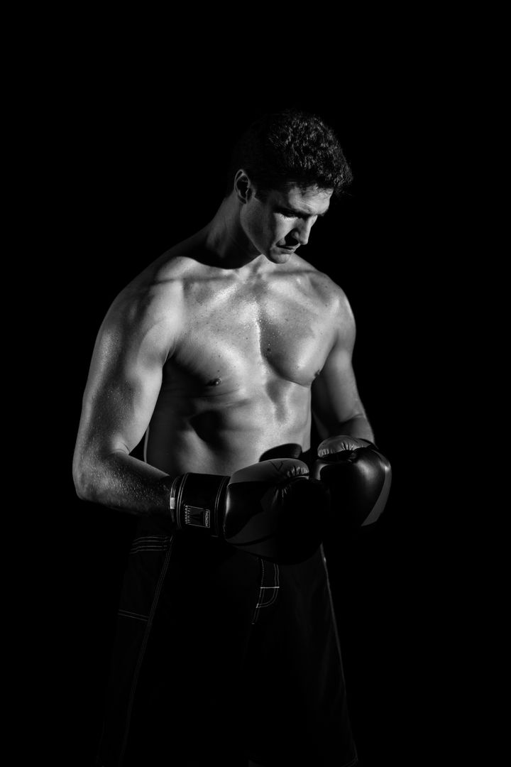 Focused Male Boxer Preparing for Training in Dark Studio - Free Images, Stock Photos and Pictures on Pikwizard.com