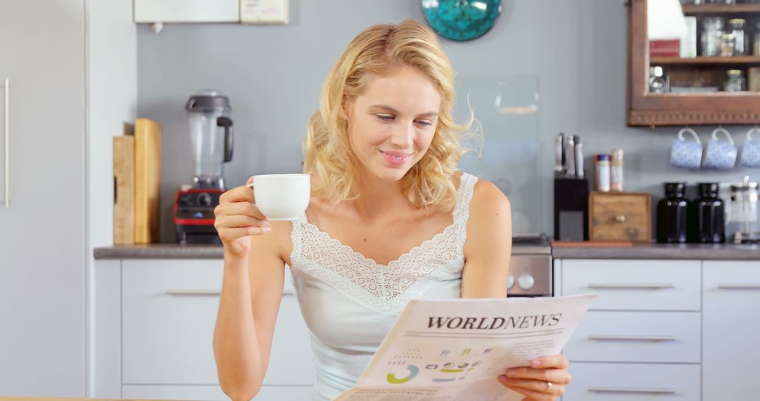 Smiling Woman Relaxing with Newspaper and Coffee in Cozy Home Kitchen - Free Images, Stock Photos and Pictures on Pikwizard.com