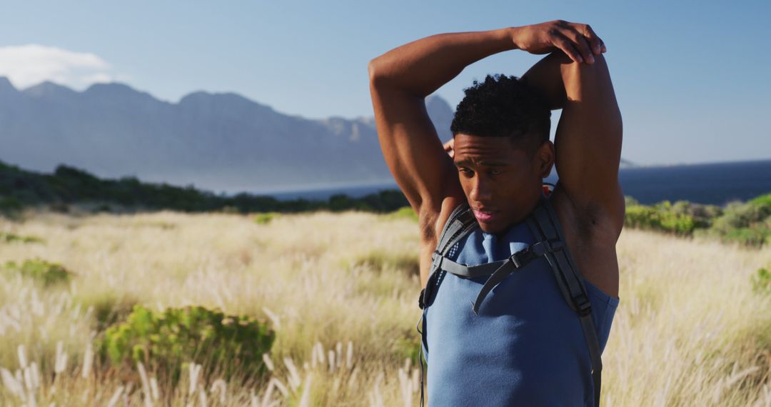 Young African American Man Stretching Outdoors in Mountain Landscape - Free Images, Stock Photos and Pictures on Pikwizard.com