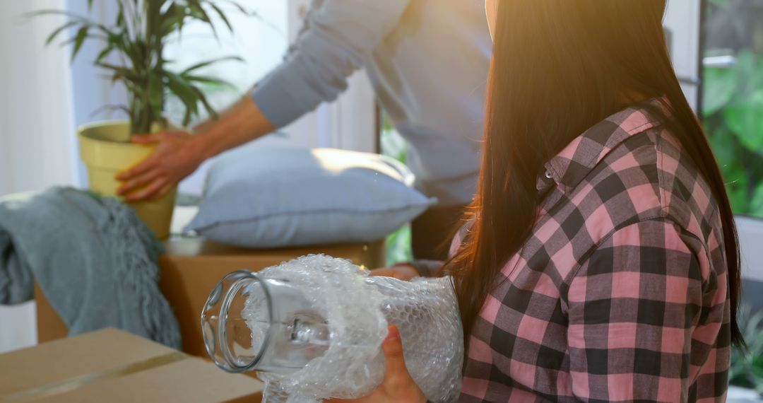 Couple Unpacking in New Home with Moving Boxes and Plants