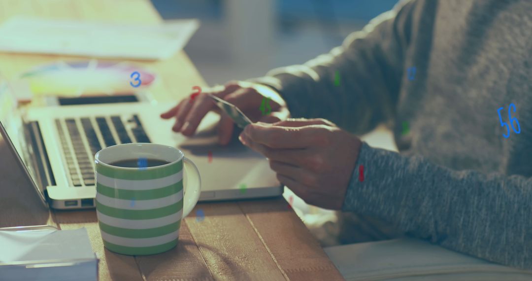 Man Engaging in Online Payment on Laptop with Digital Graphics