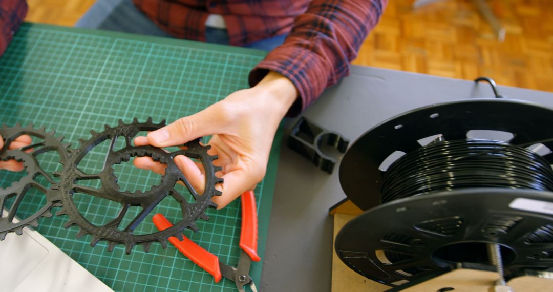 Person Examining Bicycle Gear Parts in Workshop - Free Images, Stock Photos and Pictures on Pikwizard.com