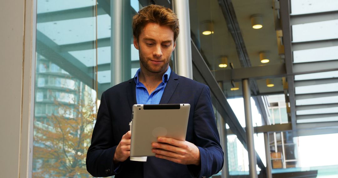 Young Professional Man Using Tablet in Modern Office - Free Images, Stock Photos and Pictures on Pikwizard.com